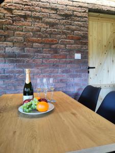 a bottle of wine and a plate of fruit on a table at Na Zaciszu in Cierzpięty