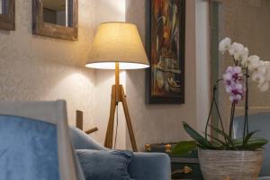 a living room with a blue couch and a lamp at Mali Hotel Porat in Budva