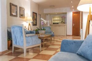 a living room with blue chairs and a table at Mali Hotel Porat in Budva