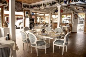 comedor con mesa blanca y sillas en Mali Hotel Porat, en Budva