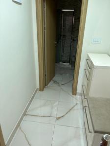 ein Badezimmerboden mit weißen Fliesen auf dem Boden in der Unterkunft Lena 4 Apartmens in Subotica
