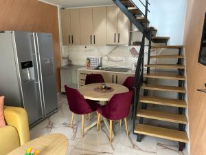 eine Küche mit einem Tisch und Stühlen sowie eine Wendeltreppe in der Unterkunft Lena 4 Apartmens in Subotica