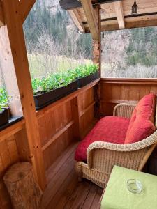 eine abgeschirmte Veranda mit einer Bank und einem Tisch in der Unterkunft "Terrasse" Nessental in Gadmen