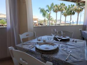 a table with a plate and wine glasses on it at Case Vacanze Ancora in Porto Empedocle