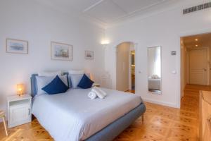 カンヌにあるPalais Miramarのベッドルーム(青い枕の大きな白いベッド付)