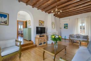 a living room with a couch and a tv at SAIL VILLA in Naousa