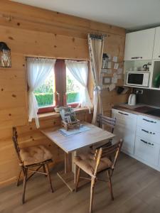 a kitchen with a table and chairs in a cabin at Vintgar studio in Bled