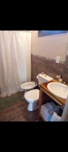a bathroom with a toilet and a sink at La Quina. in Villa Rumipal +13 photos