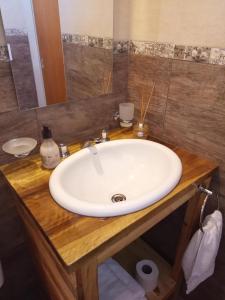 Un baño con un lavabo blanco y un espejo. en La Quina., en Villa Rumipal