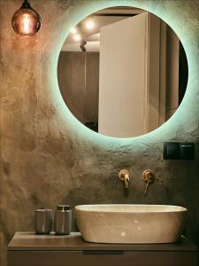 ein Bad mit einem Waschbecken und einem Spiegel in der Unterkunft Art House in Danzig