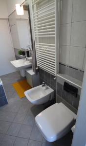 a bathroom with two sinks and a toilet and a mirror at Apartment Flora in Pula +16 photos