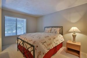 Seven Springs Sunridge 3 Bedroom Standard Condo, Sleep 10! condo في Champion: غرفة نوم بها سرير ومصباح ونافذة