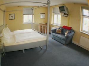 a room with a bed and a couch and a chair at Landgasthof zur krummen Linde in Stolpe +13 photos
