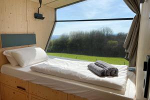 a bed in a room with a large window at Sleep Space 1 - Green Tiny Spot Dolmar 