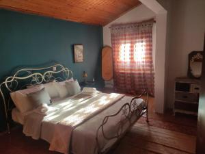 a bedroom with a large bed in a room at ΠΕΤΡΙΝΗ ΚΑΤΟΙΚΙΑ ΣΤΗΝ ΦΥΣΗ in Tagarades
