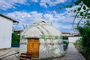uma casa cúpula com uma porta de madeira num quintal em Guest house "NIKA", Nukus em Nukus