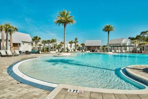 a swimming pool with palm trees in a resort at Prominence on 30A Pet Friendly Vacation Rentals by Panhandle Getaways in Watersound Beach