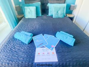 a blue bed with blue pillows and certificates on it at Casa Blue Azul in Fuzeta