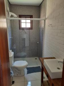 a bathroom with a toilet and a sink at Chácara Recanto Feliz in Ibiúna