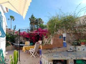 une terrasse avec une table, des chaises et des plantes dans l'établissement White villa few steps from most amazing beaches in Denia, swimming pool,parking, à Dénia