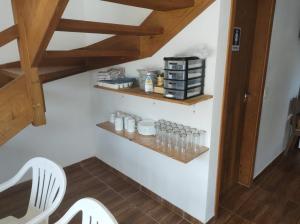 Habitación con 2 sillas blancas y escaleras de madera en Pousada Recanto das Margaridas en Boicucanga