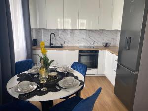 a kitchen with a table with plates and wine glasses at UniLove Apartamenty in Uniejow +12 photos