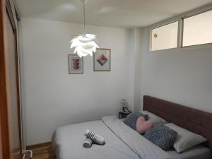 sypialnia z łóżkiem i żyrandolem w obiekcie Bulevar apartment & Free Garage w Sarajewie