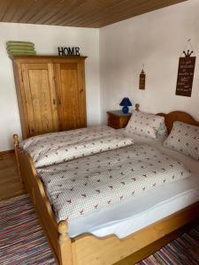 Schlafzimmer mit einem Holzbett mit einem Kopfteil aus Holz in der Unterkunft Freudenmacher in Sankt Ulrich am Pillersee