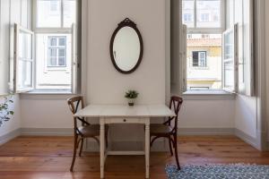 a dining room with a table and chairs and a mirror at FLH Lux Baixa Flat - Historical Center near Tejo River in Lisbon