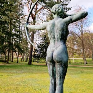 a statue of a woman with a bow in a park at Villa Bleichröder in Heringsdorf