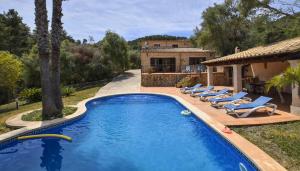 einen Pool mit Liegestühlen und ein Haus in der Unterkunft Can Petit in Sant Joan