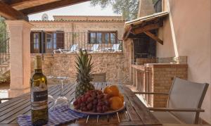 eine Flasche Wein und ein Obstteller auf dem Tisch in der Unterkunft Can Petit in Sant Joan