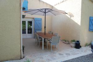stół i krzesła z parasolem na patio w obiekcie La Lezardière Gorges du Verdon w mieście Régusse