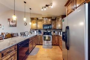 a kitchen with wooden cabinets and a stainless steel refrigerator at The Bluffs Lakeview in Branson