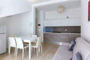 uma cozinha e sala de jantar com uma mesa branca e cadeiras em Condominio Stella em Lido di Jesolo