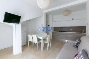 uma cozinha e sala de estar com mesa e cadeiras em Condominio Stella em Lido di Jesolo