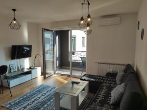 a living room with a couch and a table at Bulevar apartment & Free Garage in Sarajevo