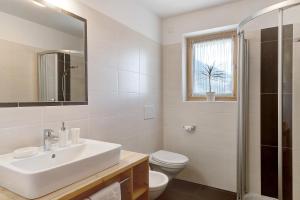 een witte badkamer met een wastafel en een toilet bij Stiflerhof Apt Enzian in Falzes