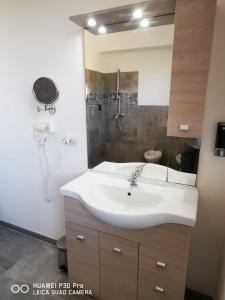 een badkamer met een witte wastafel en een douche bij Residence IL CARRUBO in Gallipoli