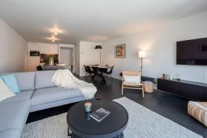 BEACH 52 duplex appartement met terras في كنوك هايست: غرفة معيشة مع أريكة زرقاء وطاولة