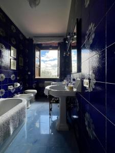 uma casa de banho com 2 lavatórios, uma banheira e 2 WC em VILLA GIOTTO Florence em Pozzolatico