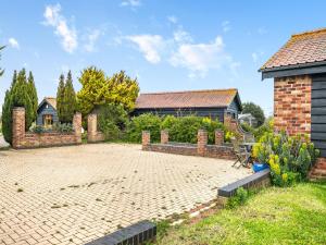 a brick courtyard in front of a house at Dairy Cottage in Saint Osyth