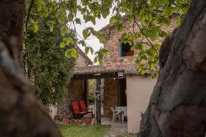 a stone house with red chairs and a table at La Casa de Salinas in Salinas de Pisuerga