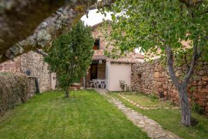 an external view of a stone house with a yard at La Casa de Salinas in Salinas de Pisuerga