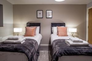 a bedroom with two beds with pillows on them at Luxury apartment 5 min to city centre*free parking in Newcastle upon Tyne