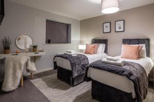 um quarto com 2 camas e um espelho em Luxury apartment 5 min to city centre*free parking em Newcastle upon Tyne