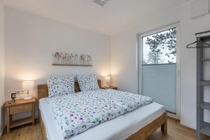 a bedroom with a large bed and a window at Tinyhaus Brekendorf Kammberg in Brekendorf