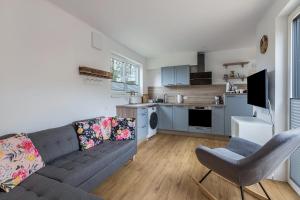 a living room with a couch and a kitchen at Tinyhaus Brekendorf Kammberg in Brekendorf