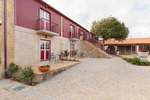 una calle adoquinada frente a un edificio rojo en Quinta de Castelhão, en Barcelos