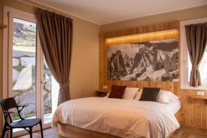 um quarto com uma cama com uma fotografia na parede em Garni Le Grigne em Barzio